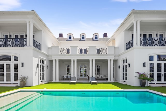 rear view of property featuring french doors, an outdoor living space, and a patio area