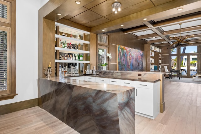 bar featuring white cabinetry, an inviting chandelier, beamed ceiling, butcher block countertops, and light hardwood / wood-style floors