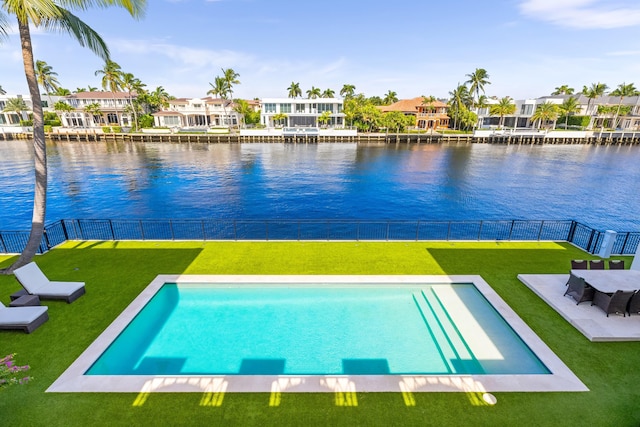 view of pool featuring a water view and a yard