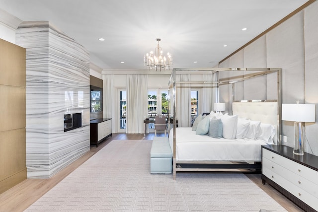 bedroom featuring an inviting chandelier, light hardwood / wood-style flooring, and crown molding