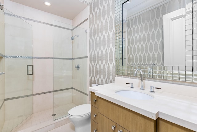 bathroom with vanity, toilet, and a shower with door