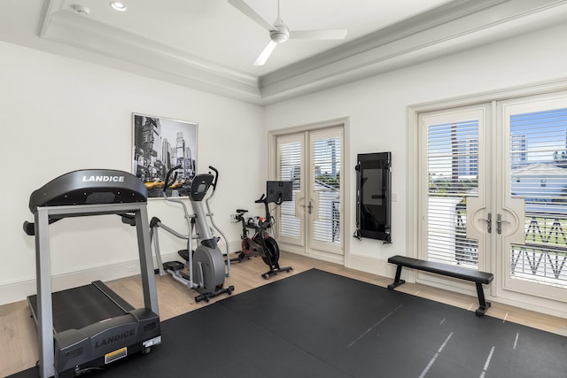 workout room with a raised ceiling, ceiling fan, french doors, and hardwood / wood-style floors