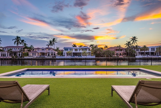 view of property's community featuring a water view, a pool, and a lawn