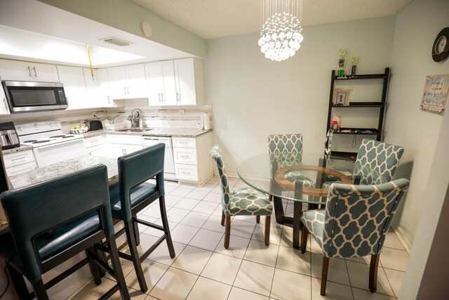 interior space featuring a chandelier, white cabinets, backsplash, white appliances, and sink