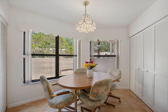 tiled dining space with a textured ceiling