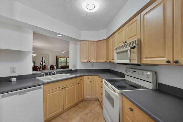 kitchen with sink, a textured ceiling, light brown cabinetry, and white appliances