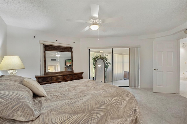 bedroom featuring ceiling fan, light colored carpet, a closet, and a textured ceiling