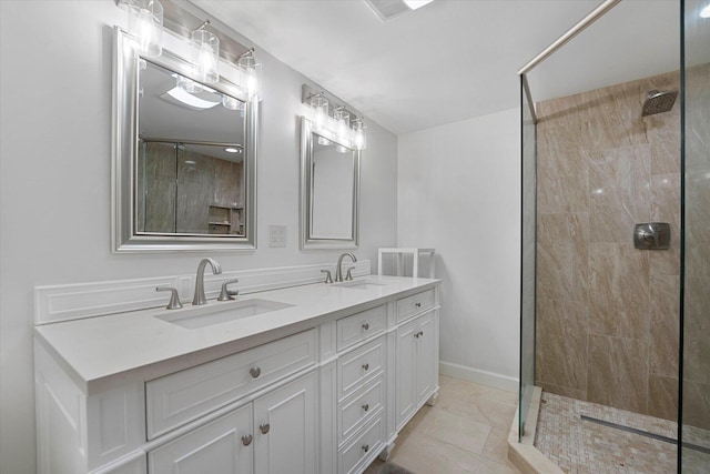 bathroom with vanity, tile patterned flooring, and a tile shower