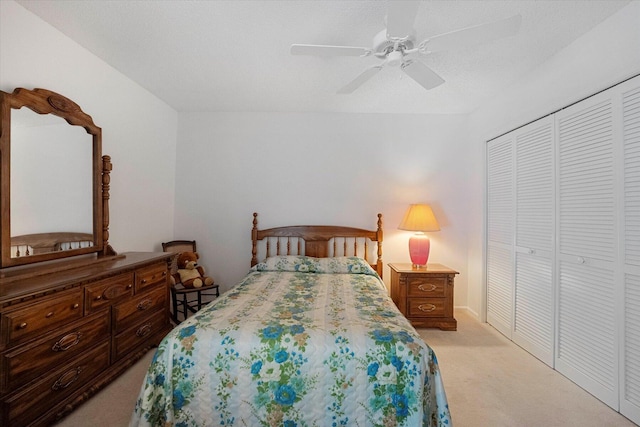 carpeted bedroom with ceiling fan and a closet