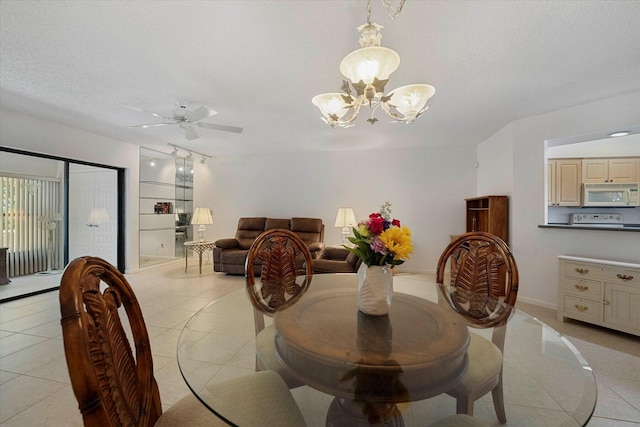 tiled dining space featuring ceiling fan with notable chandelier and a textured ceiling