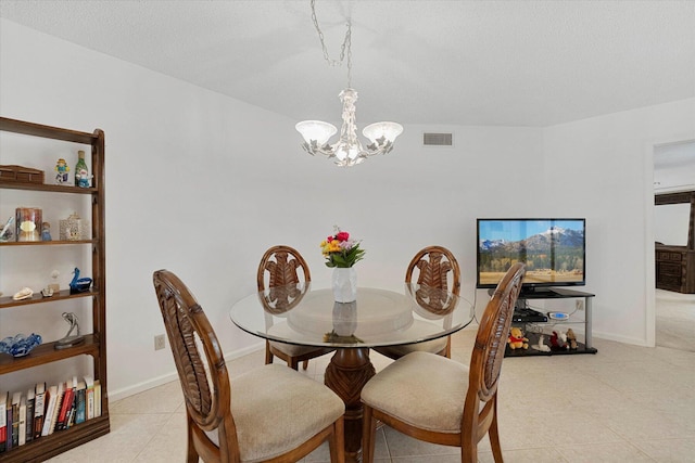 dining space with a textured ceiling and a notable chandelier