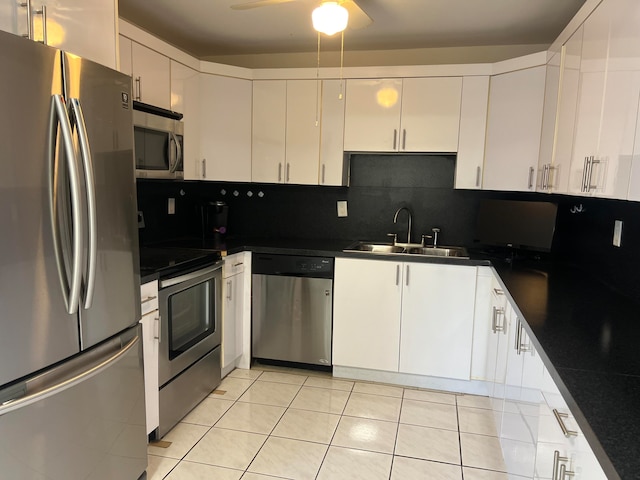 kitchen featuring decorative backsplash, ceiling fan, white cabinets, stainless steel appliances, and sink