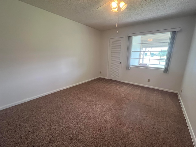 carpeted spare room featuring a textured ceiling and ceiling fan