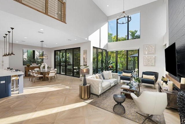 living room featuring a high ceiling, light parquet flooring, and a notable chandelier