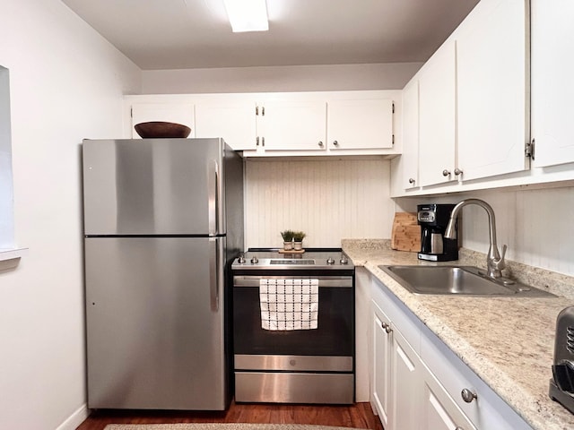 320 Horizons W Unit 103, Boynton Beach, FL 33435 - kitchen with appliances with stainless steel finishes, a sink, dark wood finished floors, and white cabinetry