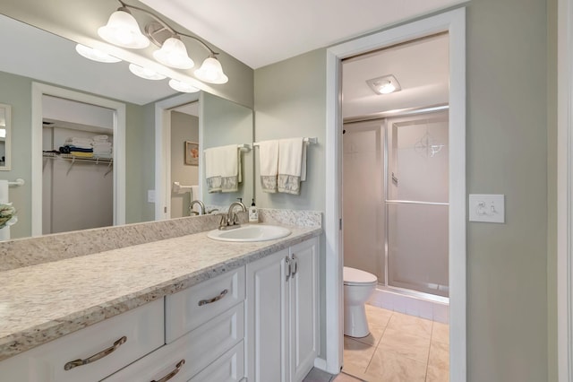 bathroom featuring vanity, toilet, an enclosed shower, and tile patterned floors