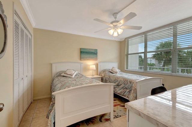 tiled bedroom featuring ornamental molding, ceiling fan, and a closet