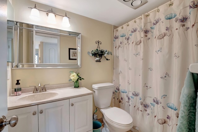 bathroom with curtained shower, toilet, and vanity