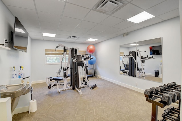 workout room featuring carpet and a drop ceiling