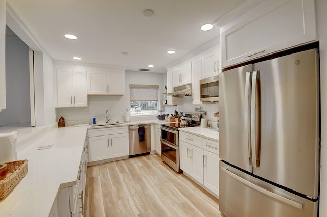 kitchen featuring light hardwood / wood-style flooring, sink, appliances with stainless steel finishes, and white cabinetry