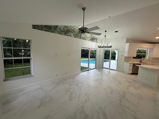 unfurnished living room with sink, lofted ceiling, light tile patterned floors, and ceiling fan with notable chandelier