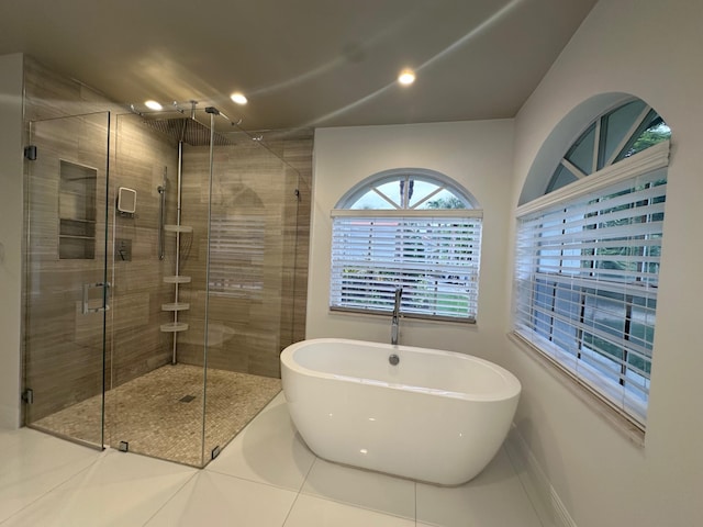 bathroom with independent shower and bath and tile patterned floors