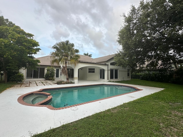 view of pool featuring an in ground hot tub, a patio area, and a yard