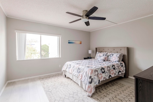 bedroom with light hardwood / wood-style floors, ornamental molding, a textured ceiling, and ceiling fan