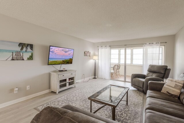 living room with light wood-type flooring and a textured ceiling