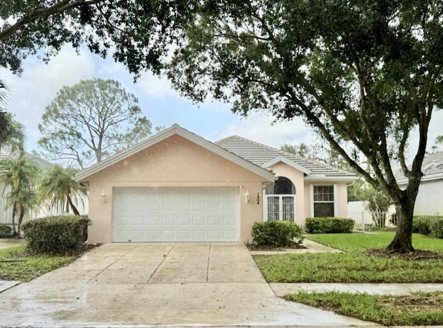 7504 SE Marsh Fern Ln, Hobe Sound, FL 33455 - ranch-style home with stucco siding, an attached garage, driveway, and a front lawn