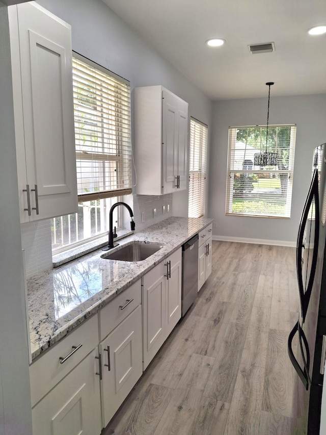 7504 SE Marsh Fern Ln, Hobe Sound, FL 33455 - kitchen with appliances with stainless steel finishes, decorative backsplash, light wood-type flooring, white cabinetry, and recessed lighting