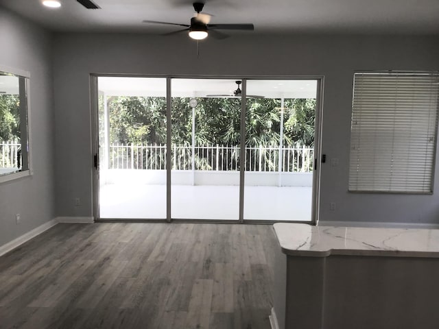 7504 SE Marsh Fern Ln, Hobe Sound, FL 33455 - unfurnished living room with ceiling fan, wood finished floors, and baseboards