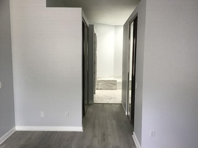 7504 SE Marsh Fern Ln, Hobe Sound, FL 33455 - hallway featuring dark wood finished floors and baseboards