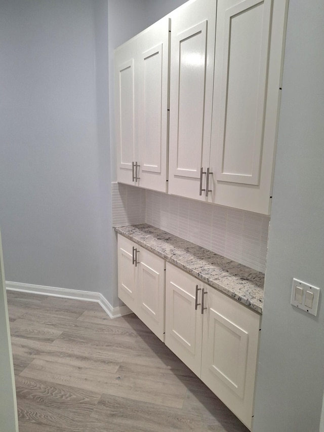 7504 SE Marsh Fern Ln, Hobe Sound, FL 33455 - bar with decorative backsplash and light wood-style floors