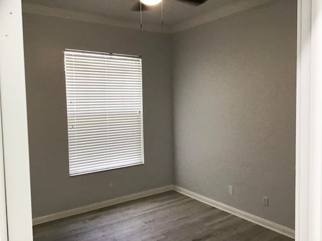 spare room with dark hardwood / wood-style floors, ceiling fan, and ornamental molding