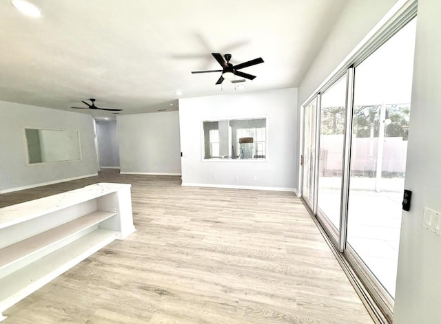 7504 SE Marsh Fern Ln, Hobe Sound, FL 33455 - unfurnished living room featuring ceiling fan, plenty of natural light, baseboards, and light wood-type flooring