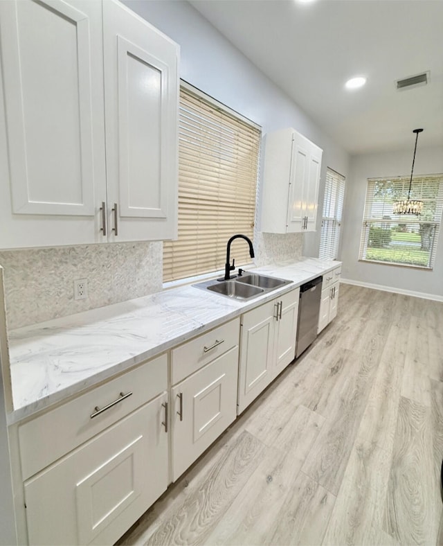 kitchen with white cabinetry, sink, stainless steel dishwasher, and light wood-type flooring