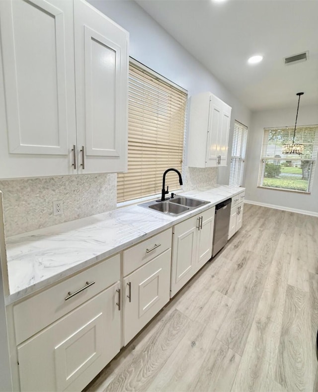 7504 SE Marsh Fern Ln, Hobe Sound, FL 33455 - kitchen featuring a sink, stainless steel dishwasher, light wood finished floors, white cabinets, and decorative backsplash