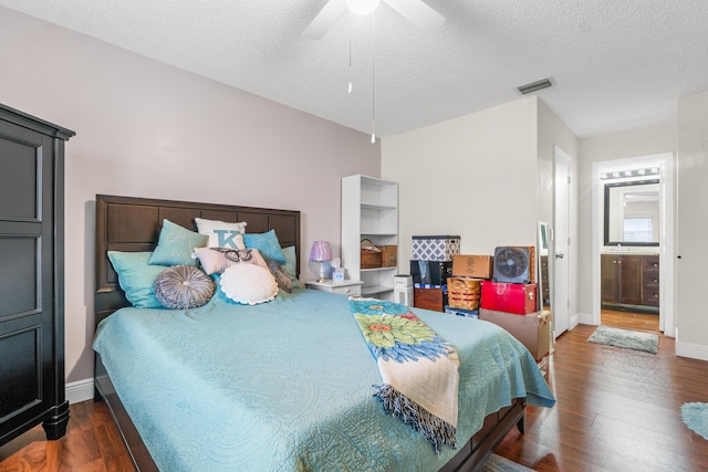 bedroom featuring ceiling fan, dark hardwood / wood-style flooring, a textured ceiling, and connected bathroom