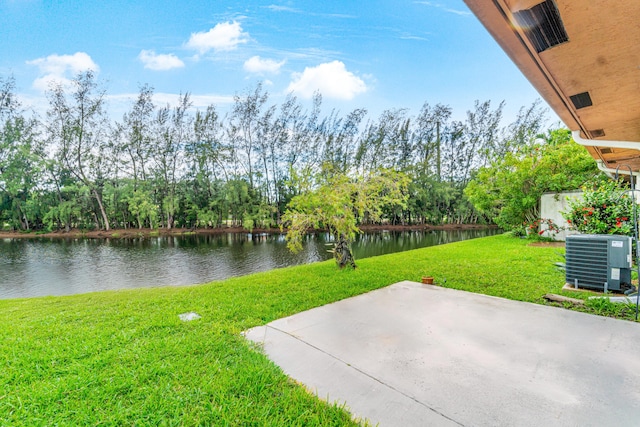 view of yard with central AC unit, a patio area, and a water view