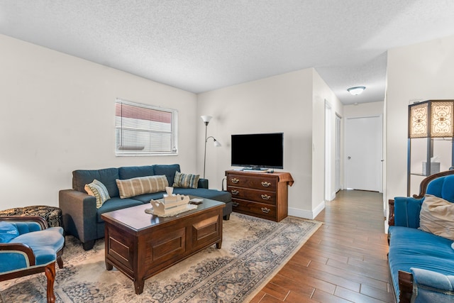 living room with light wood-type flooring and a textured ceiling