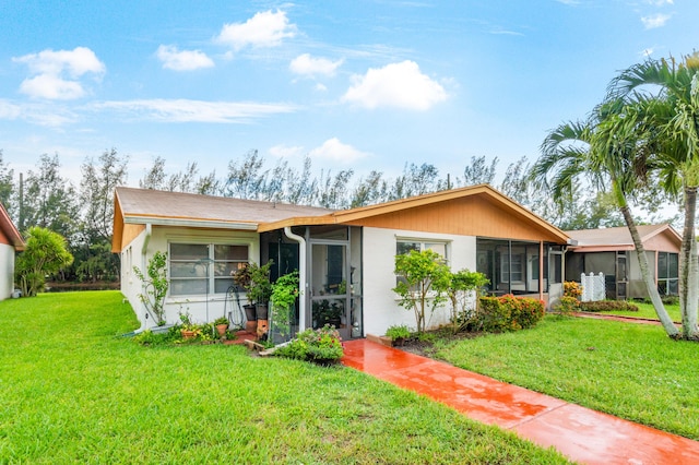 single story home with a sunroom and a front lawn