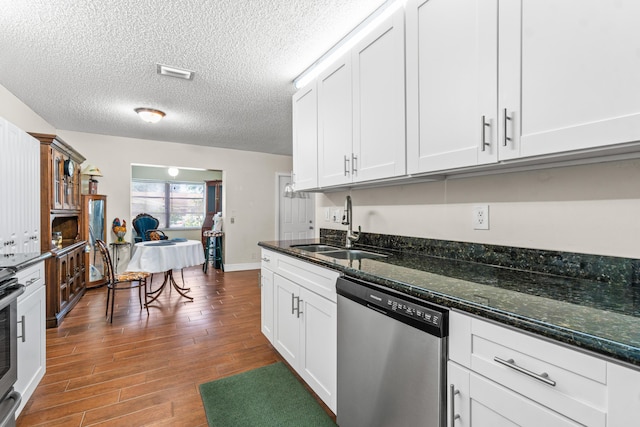 kitchen featuring white cabinetry, dishwasher, sink, dark hardwood / wood-style floors, and dark stone counters