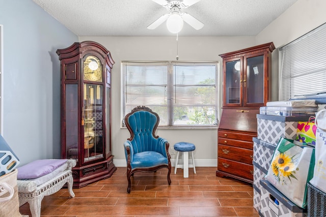 sitting room featuring a textured ceiling, hardwood / wood-style flooring, and ceiling fan