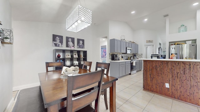 dining room featuring light tile patterned floors, recessed lighting, visible vents, high vaulted ceiling, and baseboards