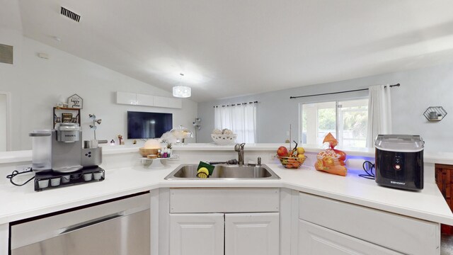 kitchen with sink, dishwasher, lofted ceiling, and white cabinets