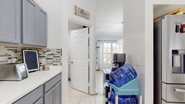 kitchen featuring stainless steel fridge with ice dispenser, gray cabinets, tasteful backsplash, and light tile patterned floors