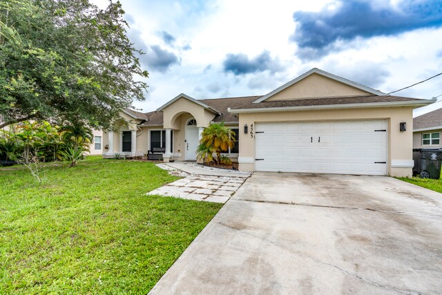 ranch-style house featuring a garage and a front lawn