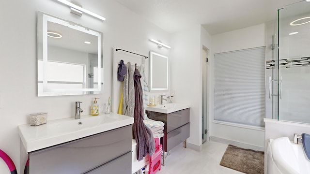 full bath featuring a stall shower, two vanities, a sink, and baseboards