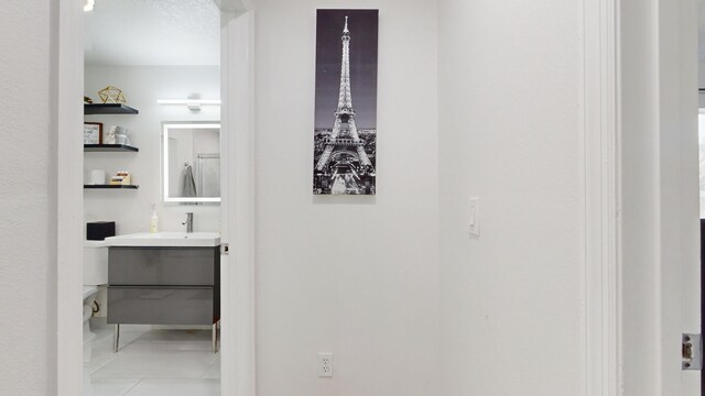 hallway with sink and light tile patterned floors